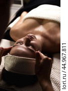 Close up of masseur hands doing relax face massage for beauty lady in medical spa room, shadow. Atmospheric anti-aging relaxing facial massaging, medical massage, wellness concept. Copy ad text space. Стоковое фото, фотограф Aleksandr Golubev / Фотобанк Лори