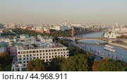 Москва. Вид на Кремль и Большой каменный мост со смотровой площадки Храма Христа Спасителя. По реке проплывают три прогулочных теплохода. Теплое солнечное вечернее освещение. Редакционное видео, видеограф Сергей Никифоров-Гордеев / Фотобанк Лори