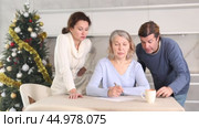 Man and woman help elderly mother make will and fill out document correctly On Christmas Eve. Стоковое видео, видеограф Яков Филимонов / Фотобанк Лори