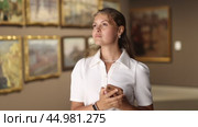 Woman with phone in hands view pictures and icons in museum hall. Стоковое видео, видеограф Яков Филимонов / Фотобанк Лори