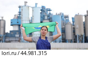 Smiling young woman worker posing with Brazil flag in hands against background of factory. Стоковое видео, видеограф Яков Филимонов / Фотобанк Лори