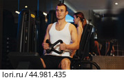 Man pulls handle of simulator with effort during strength training. Стоковое видео, видеограф Яков Филимонов / Фотобанк Лори