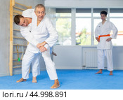 Judo or jiu jitsu classes - two men of different age practicing grabbing and throwing on sports mats. Стоковое фото, фотограф Яков Филимонов / Фотобанк Лори