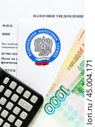 Время платить налоги. Налоговое уведомление, деньги, калькулятор и эмблема Федеральной налоговой службы. Вертикальный формат. Крупный план. Стоковое фото, фотограф Лариса Гордеева / Фотобанк Лори