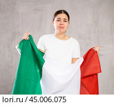 Sad young woman holding Italia flag against unicoloured background. Стоковое фото, фотограф Яков Филимонов / Фотобанк Лори