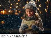 A little girl in winter clothes holding an envelope outside in snowy weather against the background of lights. A letter for Santa Claus. The winter atmosphere of a festive invitation. Стоковое AI-изображение, AI-художник Photojuli / Фотобанк Лори
