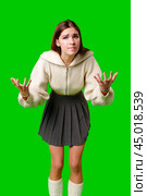 Young Woman Expressing Confusion With Hands Up Against Green Screen Background. Стоковое фото, фотограф Сергей Толмачёв / Фотобанк Лори