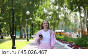 Young beautiful blonde in a pink suit walks in a summer park. Стоковое видео, видеограф Андрей Аркуша / Фотобанк Лори