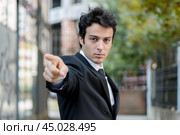Businessman pointing finger accusingly while standing outdoors. Стоковое AI-изображение, AI-художник Иван Рябоконь / Фотобанк Лори