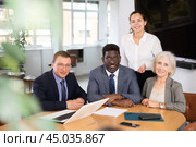Smiling business men and woman posing together sitting at the table. Стоковое фото, фотограф Яков Филимонов / Фотобанк Лори