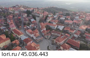 Scenic spring view from drone of Signagi township with narrow winding streets situated on hill in foothills of Gombori Range, Georgia. Стоковое видео, видеограф Яков Филимонов / Фотобанк Лори