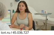 Young woman consulting with faceless beautician on anti-aging treatments in cosmetology clinic. Стоковое видео, видеограф Яков Филимонов / Фотобанк Лори