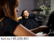 Hairstylist combing hair with comb for brunette woman in spa salon, hairstyle. Hairdresser lady make beauty hairdo, barber shop. Concept of customer service at hair salon, haircare. Copy ad text space. Стоковое фото, фотограф Aleksandr Golubev / Фотобанк Лори
