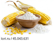 Corn starch powder in a wooden bowl surrounded by corn cobs. Стоковое AI-изображение, AI-художник Иван Рябоконь / Фотобанк Лори