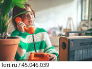 retro, cute girl teen talking on old orange vintage phone with dialer. Стоковое фото, фотограф Ольга Ильина / Фотобанк Лори