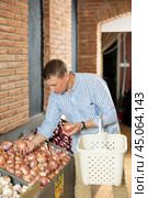 Male customer made beeline for fresh produce section, pick up onion for morning salad. Стоковое фото, фотограф Яков Филимонов / Фотобанк Лори