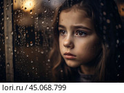 A teenage girl with a sad face alone by the window. It's raining outside the window. The concept of loneliness, depression, melancholy, resentment and bad mood. Стоковое AI-изображение, AI-художник Photojuli / Фотобанк Лори