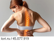 Neck and lumbar pain, intervertebral spine hernia, woman with back pain on a gray background, spinal disc disease, health problems concept. Стоковое AI-изображение, AI-художник Станислав Тарко / Фотобанк Лори