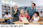 Mature female teacher asks the amused schoolchildren to behave a little quieter. Стоковое фото, фотограф Яков Филимонов / Фотобанк Лори