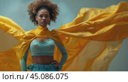 African-American young woman dressed in superhero costume with flowing yellow cape on grey background, looking at the camera, copyspace,, concept of fashion design, creative industry. Стоковое AI-видео, аниматор Ирина Михайличенко / Фотобанк Лори