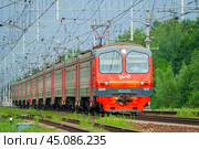 Moscow region, Russia, July 2018: Passenger electric train of the Russian Railways ED4M moves against a green trees (editorial) Редакционное фото, фотограф Михаил Строгалев / Фотобанк Лори