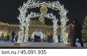 SAINT PETERSBURG, RUSSIA-December 25, 2023: Christmas and New Year holidays in Petersburg. Video of tourists walking on festively decorated St. Isaac Square with illuminated arches at Mariinsky Palace. Редакционное видео, видеограф Виктория Катьянова / Фотобанк Лори