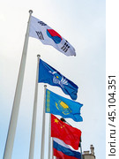 View on the flags of China, Kazakhstan, South Korea, Russia and Commonwealth of Independent States on the background of cloudy sky. Стоковое фото, фотограф Михаил Строгалев / Фотобанк Лори
