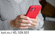 Brest, Belarus - 02 August 2022: Female hand using iphone 12. Young woman holding smartphone in her hands and scrolling through the news feed. Person texting message, touching screen on smart phone. Стоковое видео, видеограф Марина Демидюк / Фотобанк Лори