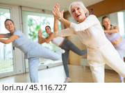 Cheerful senior female choreographer showing new dancing dynamic movements during training together with women in studio. Стоковое фото, фотограф Яков Филимонов / Фотобанк Лори
