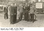 Молодые мужчины в костюмах стоят около киноафиши в 1960-е годы. Стоковое фото, фотограф Retro / Фотобанк Лори