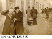 Мужнина пытается обнять за плечи женщину в пальто с меховым воротником и сумочкой на улице. 1920-е годы. Стоковое фото, фотограф Retro / Фотобанк Лори