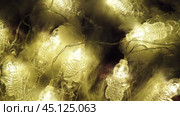 Transparent skeletons glowing yellow, close-up. Transform your space with a whimsical garland featuring glowing skeleton skulls and bones, perfect for Halloween festivities and ambiance. Horror theme. Стоковое видео, видеограф Юлия Петровская / Фотобанк Лори