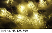 Transparent skeletons glowing yellow, close-up. Transform your space with a whimsical garland featuring glowing skeleton skulls and bones, perfect for Halloween festivities and ambiance. Horror theme. Стоковое видео, видеограф Юлия Петровская / Фотобанк Лори