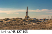 Drilling oil and gas wells in desert terrain. Sand hills, sparse vegetation. Beautiful sky. Infrastructure of the drilling rig. Стоковое фото, фотограф Владимир Ендовицкий / Фотобанк Лори
