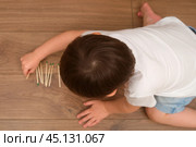 A matchstick in the child's hand can quickly lead to a fire hazard. The baby is dangerously close to the burning flame while playing at home. Kid aged 3 years (three year old boy) Стоковое фото, фотограф Андрей Журавлев / Фотобанк Лори
