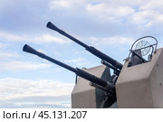 Double-barreled naval automatic cannon against the sky close-up, military background. Стоковое фото, фотограф Евгений Харитонов / Фотобанк Лори