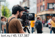 The cameraman is preparing to shoot an interview on the street. Стоковое AI-изображение, AI-художник Ярославский Максим / Фотобанк Лори