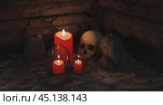 Red candles burning near skull in a scary dungeon. Стоковое видео, видеограф Данил Руденко / Фотобанк Лори