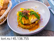 Codfish baked with curry and served with quinoa and greens. Стоковое фото, фотограф Яков Филимонов / Фотобанк Лори