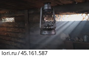 A wooden dugout in which a kerosene lamp burns. Light from the window penetrates into the room. Стоковое видео, видеограф Александр Кузовков / Фотобанк Лори