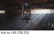 A wooden dugout in which a kerosene lamp burns. Light from the window penetrates into the room. Стоковое видео, видеограф Александр Кузовков / Фотобанк Лори