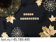 The inscription happy Halloween. Modern background with black bats, Golden leaves, cobwebs and wooden letters. Halloween with copy space for text. Flat lay, top. Стоковое фото, фотограф Photojuli / Фотобанк Лори