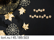 The inscription happy Halloween. Modern background with black bats, Golden leaves, cobwebs and wooden letters. Halloween with copy space for text. Flat lay, top. Стоковое фото, фотограф Photojuli / Фотобанк Лори