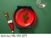 Christmas table setting with red plate on green. Xmas dinner. Стоковое фото, фотограф Светлана Лажко / Фотобанк Лори