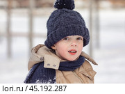 Portrait of cute little boy in beige winter clothes walks in winter park during a snowfall. Baby having fun. Cute child in a warm hat and scarf soiled in the snow. Outdoors winter activities for kids. Стоковое фото, фотограф Ирина Михайличенко / Фотобанк Лори