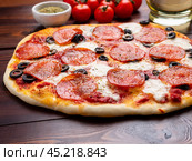 hot homemade Italian pepperoni pizza with salami, mozzarella and olives. Стоковое фото, фотограф Natalia Gdovskaia / Фотобанк Лори