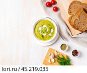 large white bowl with vegetable green cream soup of broccoli, zucchini, green peas. Стоковое фото, фотограф Natalia Gdovskaia / Фотобанк Лори
