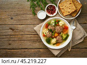 meatballs soup in white plate on old wooden rustic grey table, top view. Стоковое фото, фотограф Natalia Gdovskaia / Фотобанк Лори