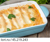 Cannelloni with filling of ground beef, tomatoes, baked with bechamel tomato sauce, side view, old dark wooden background. Стоковое фото, фотограф Natalia Gdovskaia / Фотобанк Лори