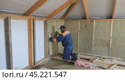 Insulation of a frame house with mineral wool. Cutting, fitting, laying insulation. Construction works. Стоковое видео, видеограф Константин Мерцалов / Фотобанк Лори